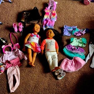 American girl dolls with some clothes and shoes and other items.